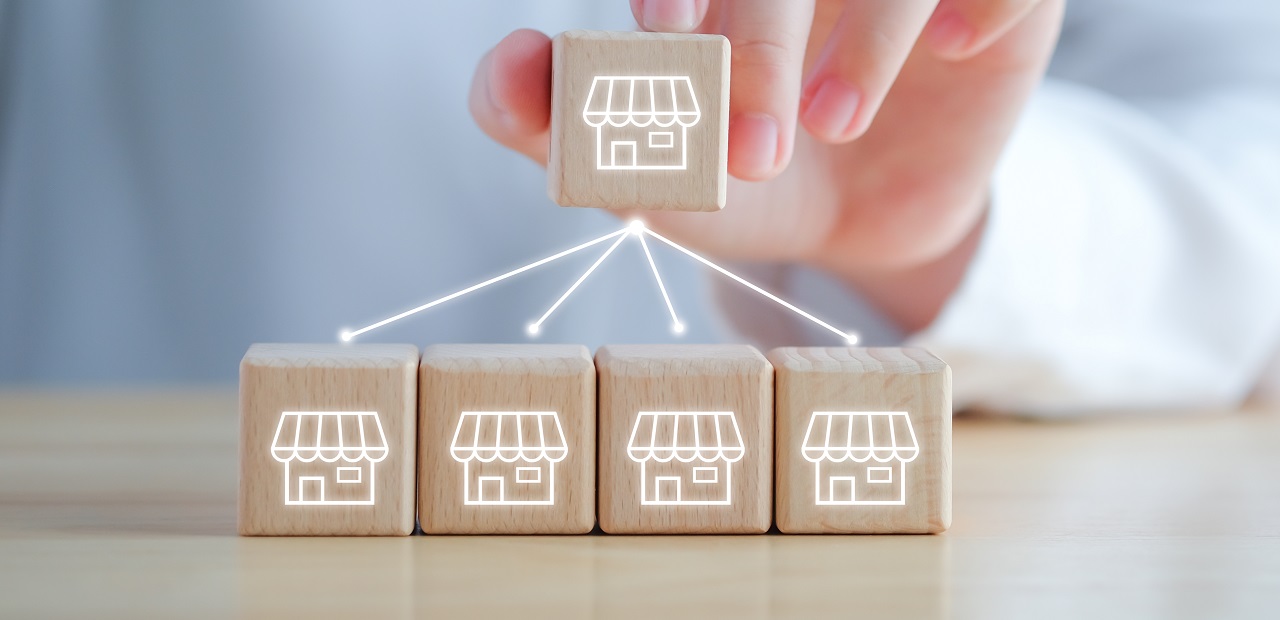 Hand holds a wooden block with arrows pointing downwards towards other blocks.